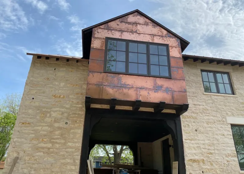 Copper metal panel facade on a stone building for Skylight Installation in Orion
